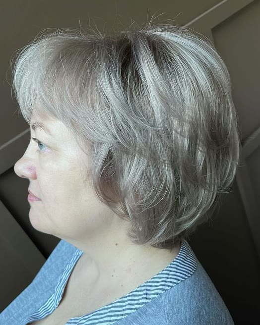 Short, layered silver-blonde bob, seen in profile