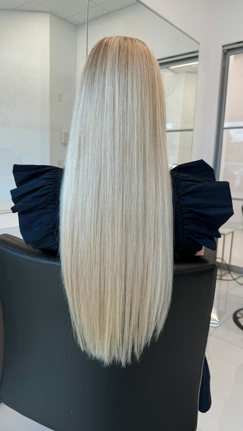 Very long, straight platinum-blonde hair, seen from behind