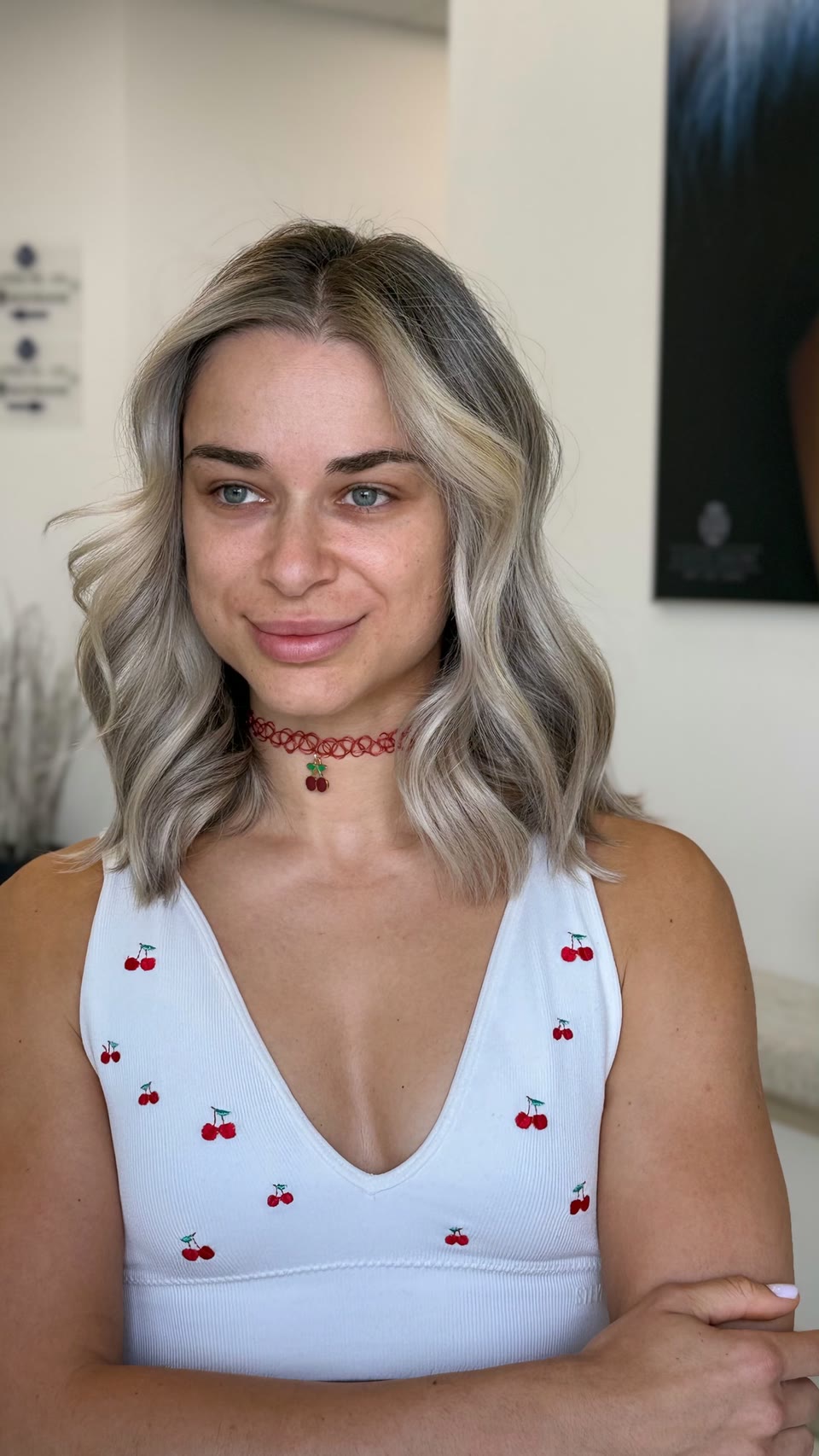 Shoulder-length ash-blonde waves with a darker root and bright face-framing pieces