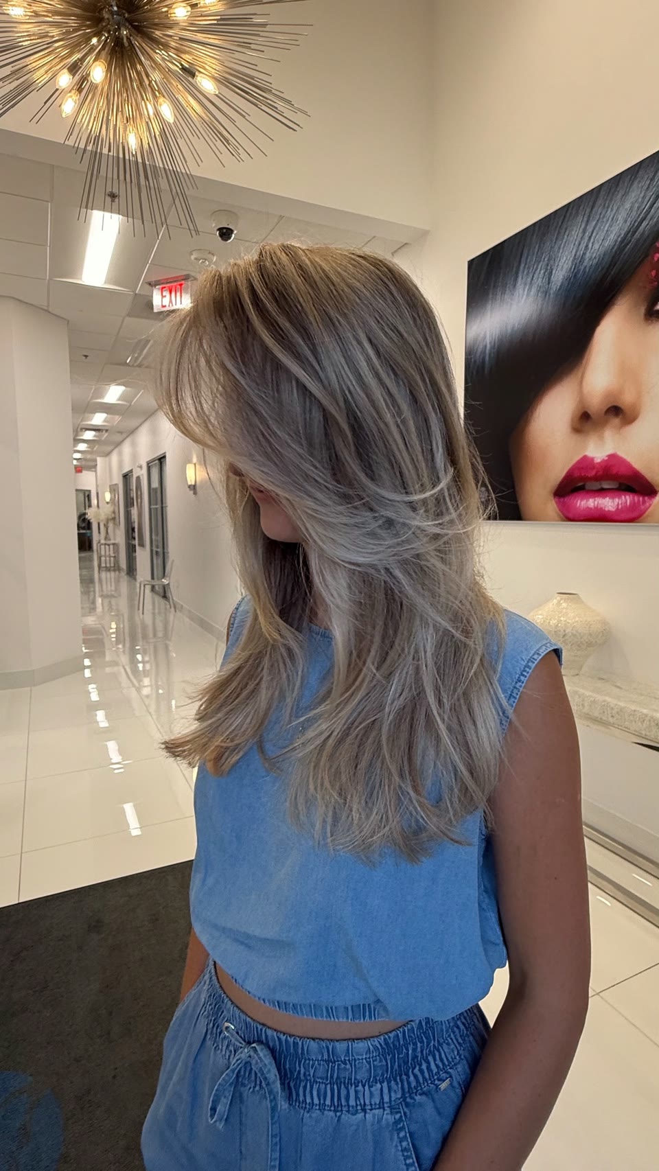Long, layered ash-blonde hair with face-framing pieces, seen from the side