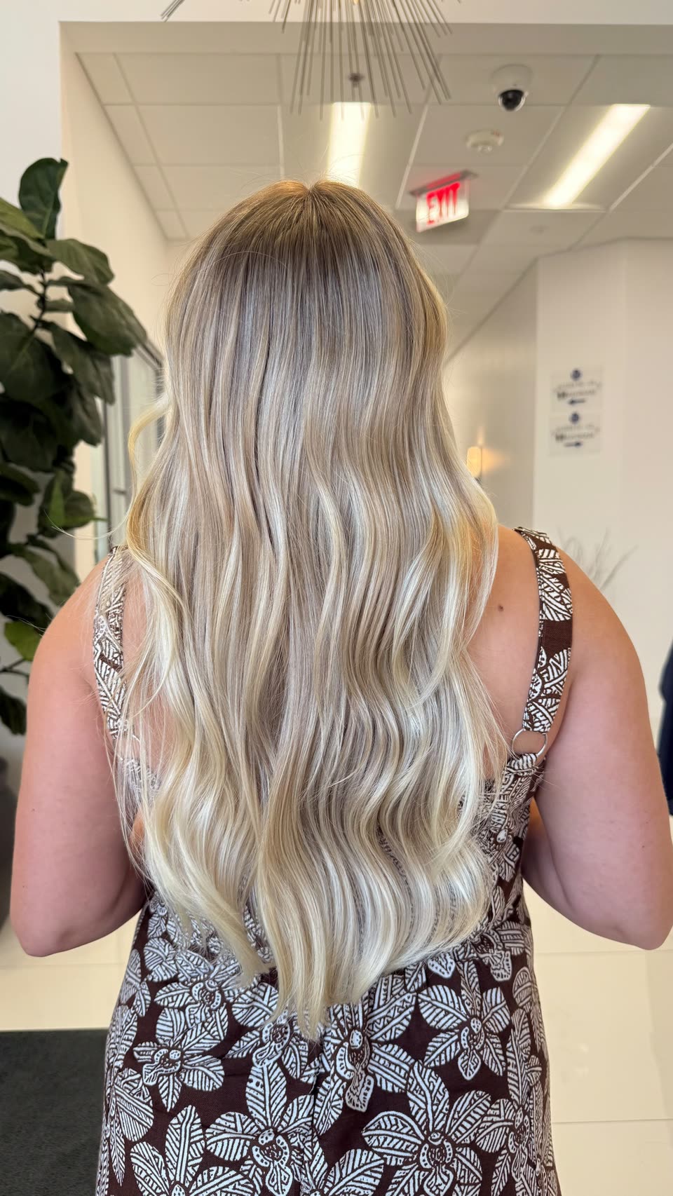 Long, light-blonde waves with a soft root, seen from behind