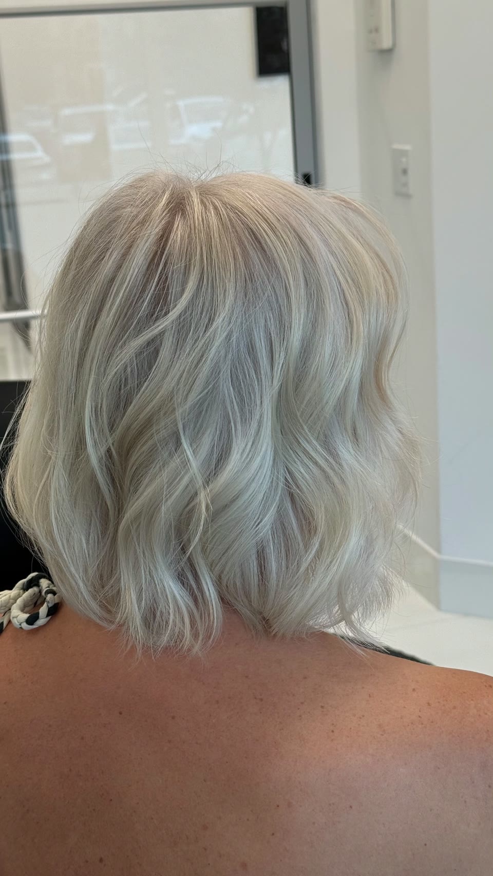 Platinum-blonde bob in soft waves, seen from behind