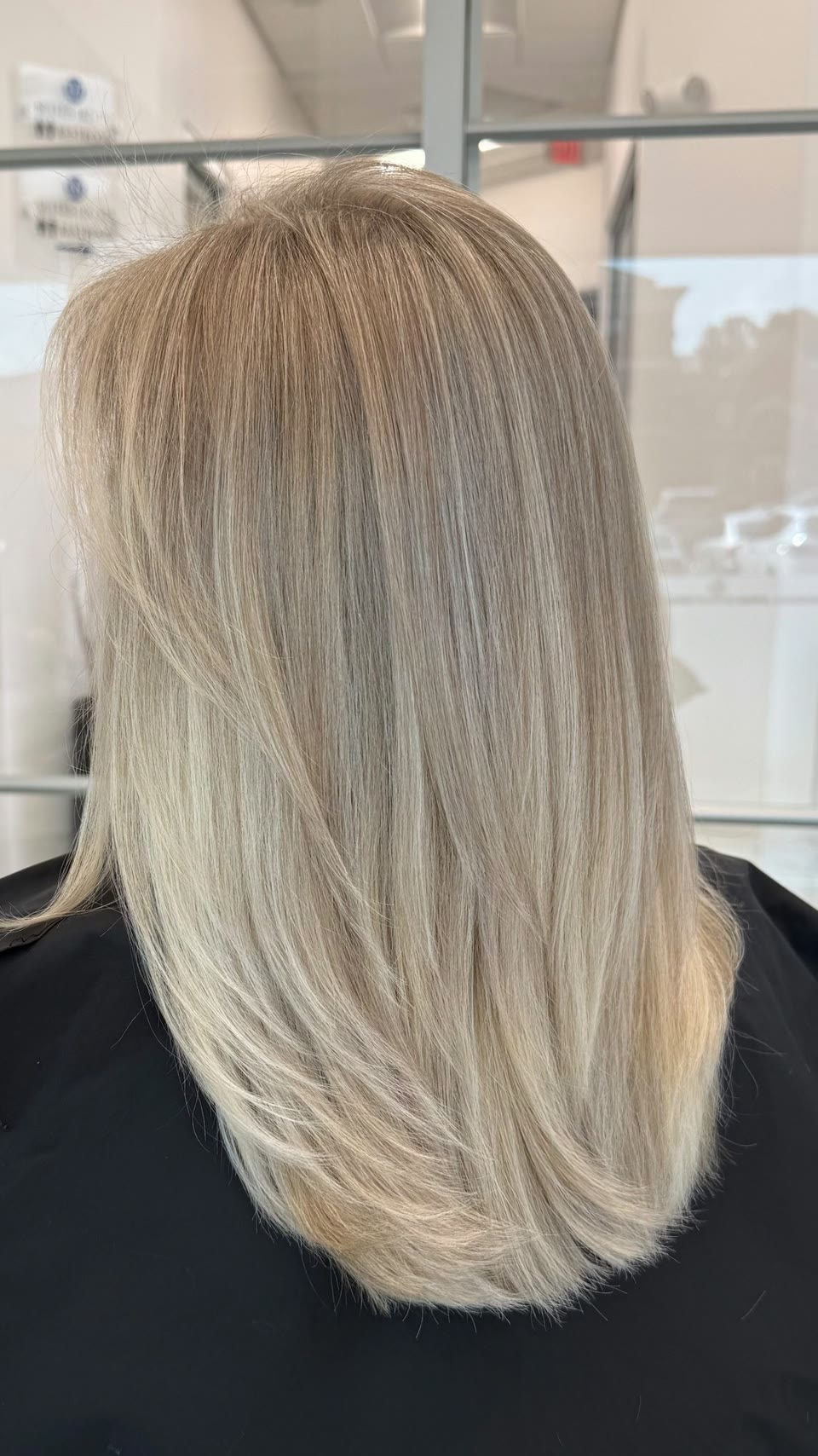 Shoulder-length, straight icy-blonde hair with soft layers, seen from behind